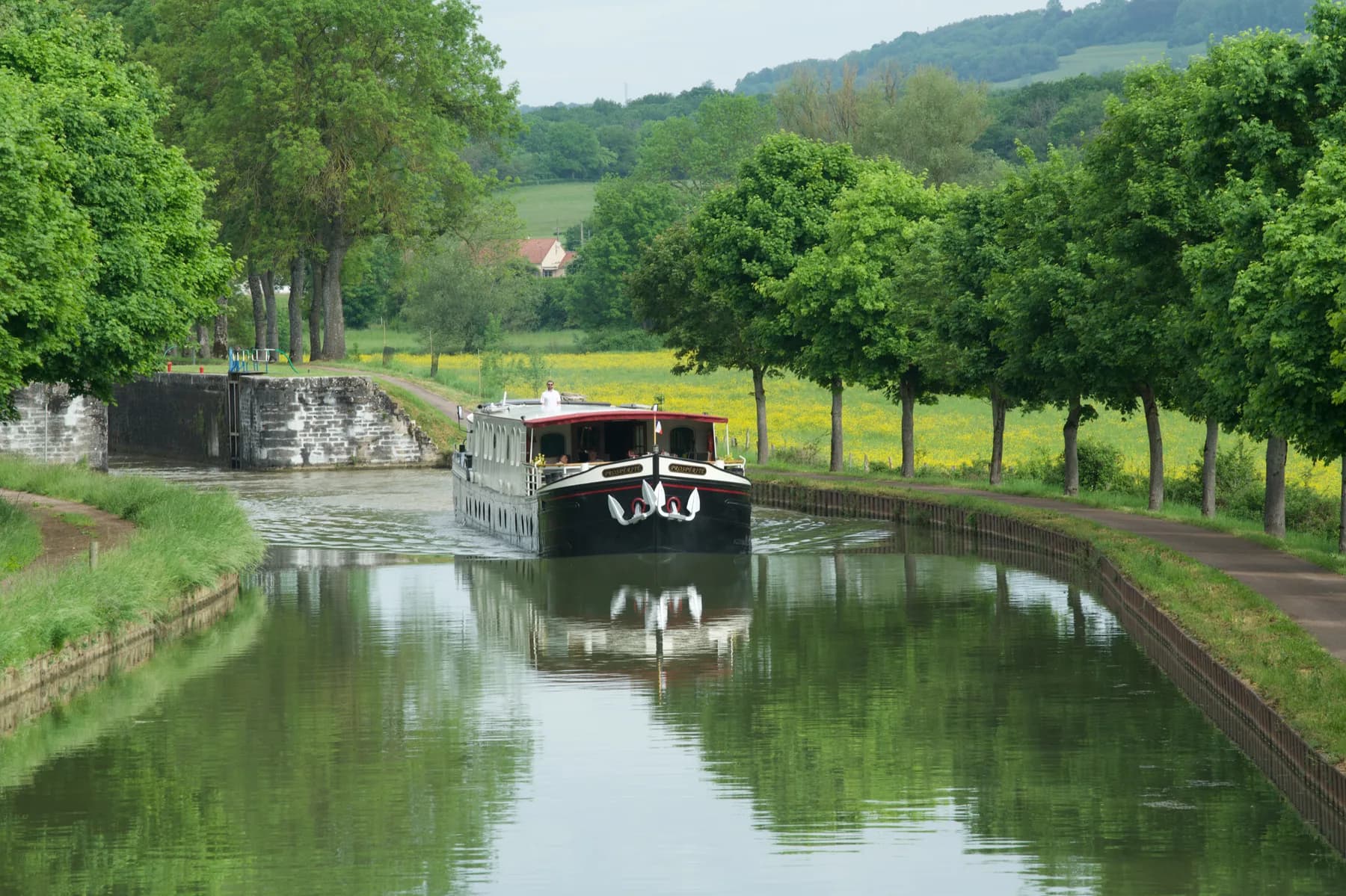 Approaching a lock on a tree-lined canal