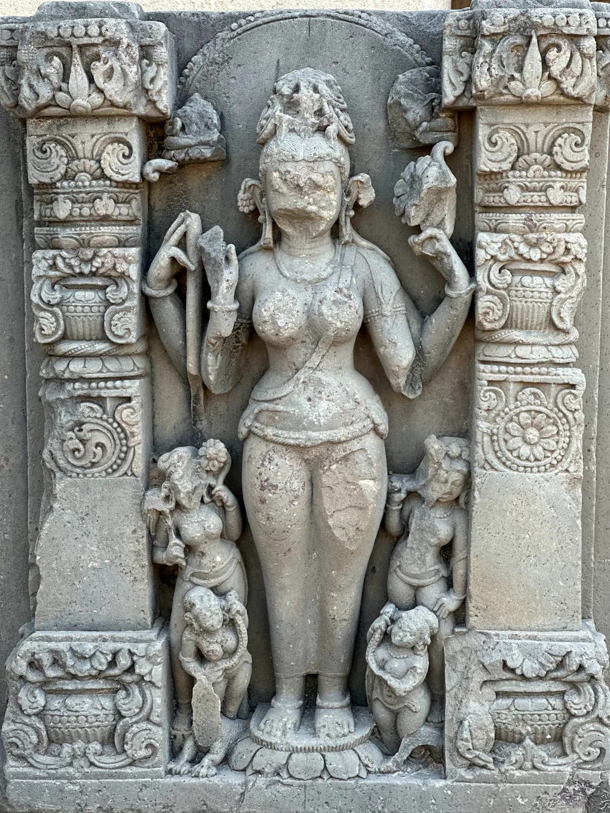 Una diosa de piedra tallada flanqueada por sus acompañantes en las arcadas de Chand Baori, en Abhaneri