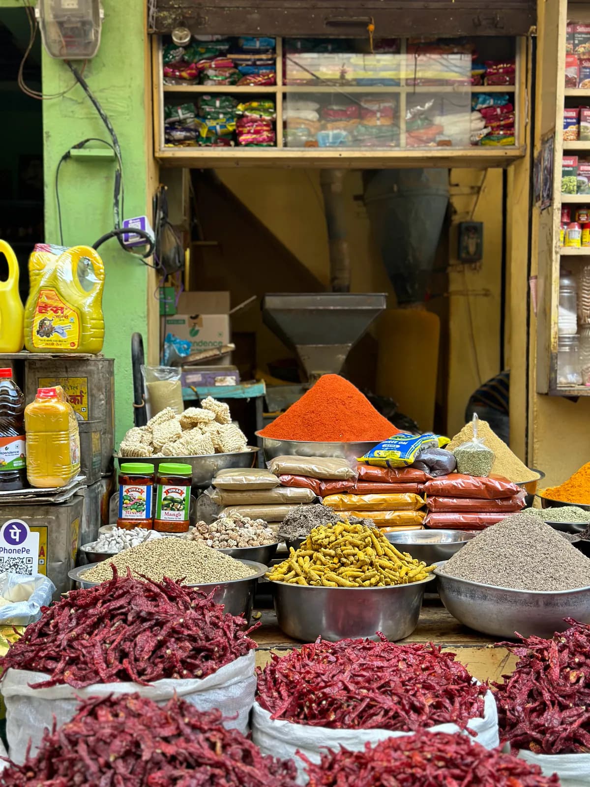 Sacos de guindillas rojas secas, cúrcuma y especias a la puerta de una tienda pequeña del casco antiguo de Udaipur