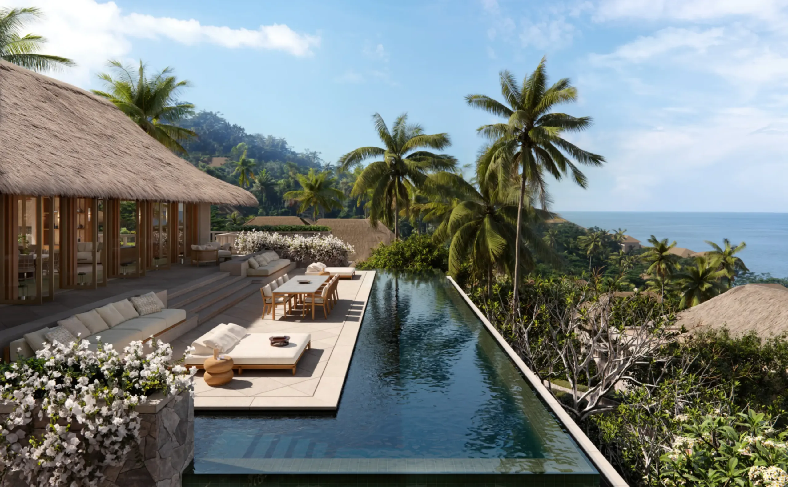 The terrace of a residence at Amankila: a dark-tiled pool running the length of a thatched pavilion, daybeds and frangipani along its edge, and the Bali Sea through the palms.