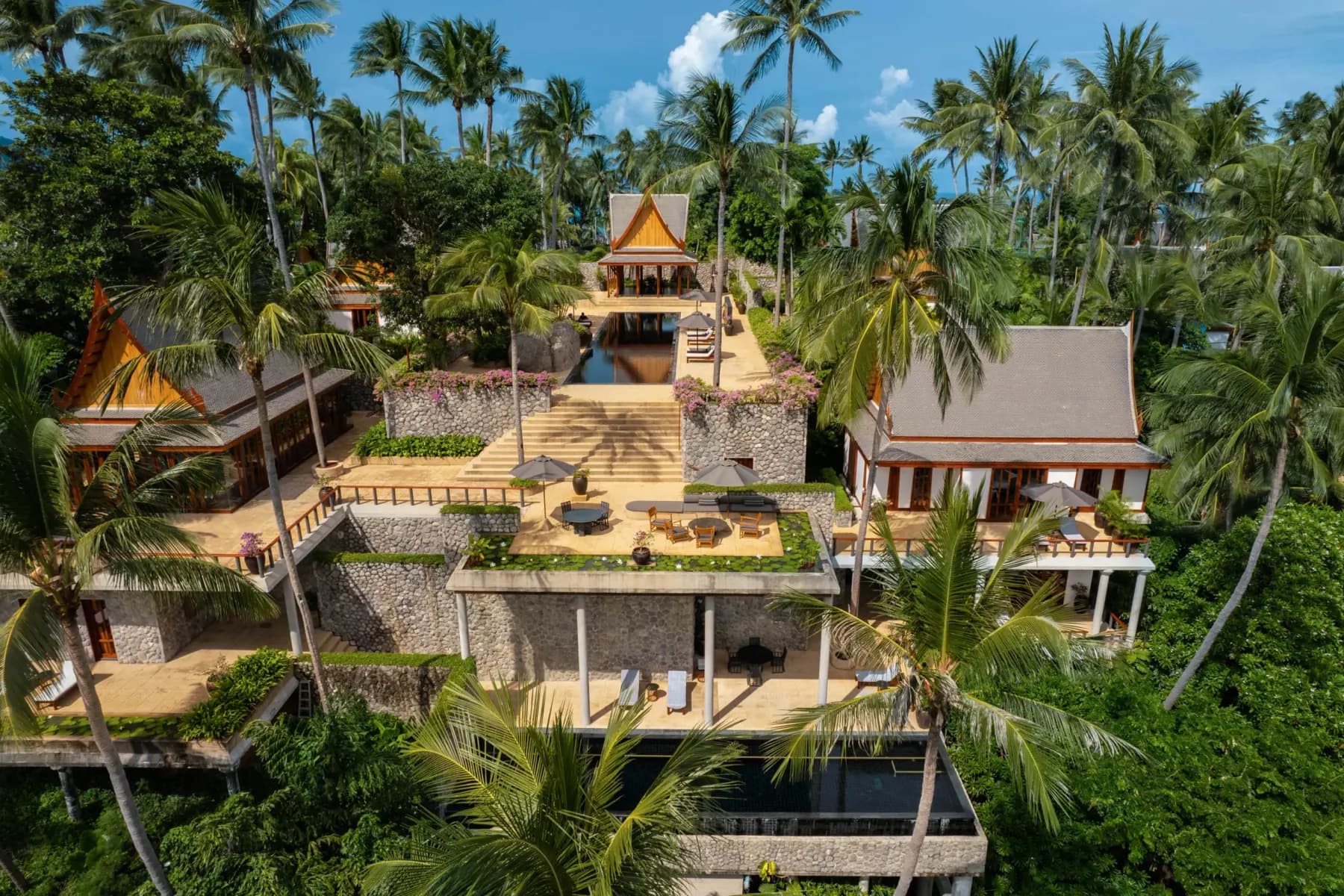 An Amanpuri villa from above: pavilions, a private pool and terraces under the coconut palms of Pansea Beach.