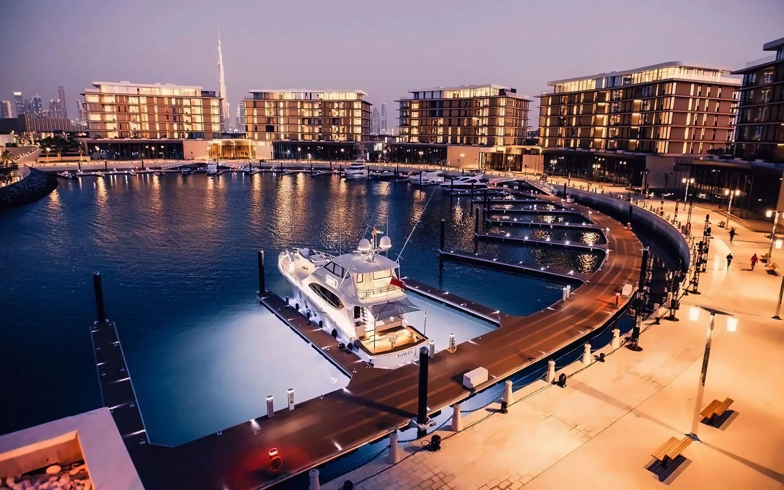The residence buildings and the marina of Bulgari Resort & Residences Dubai on Jumeirah Bay Island at dusk.