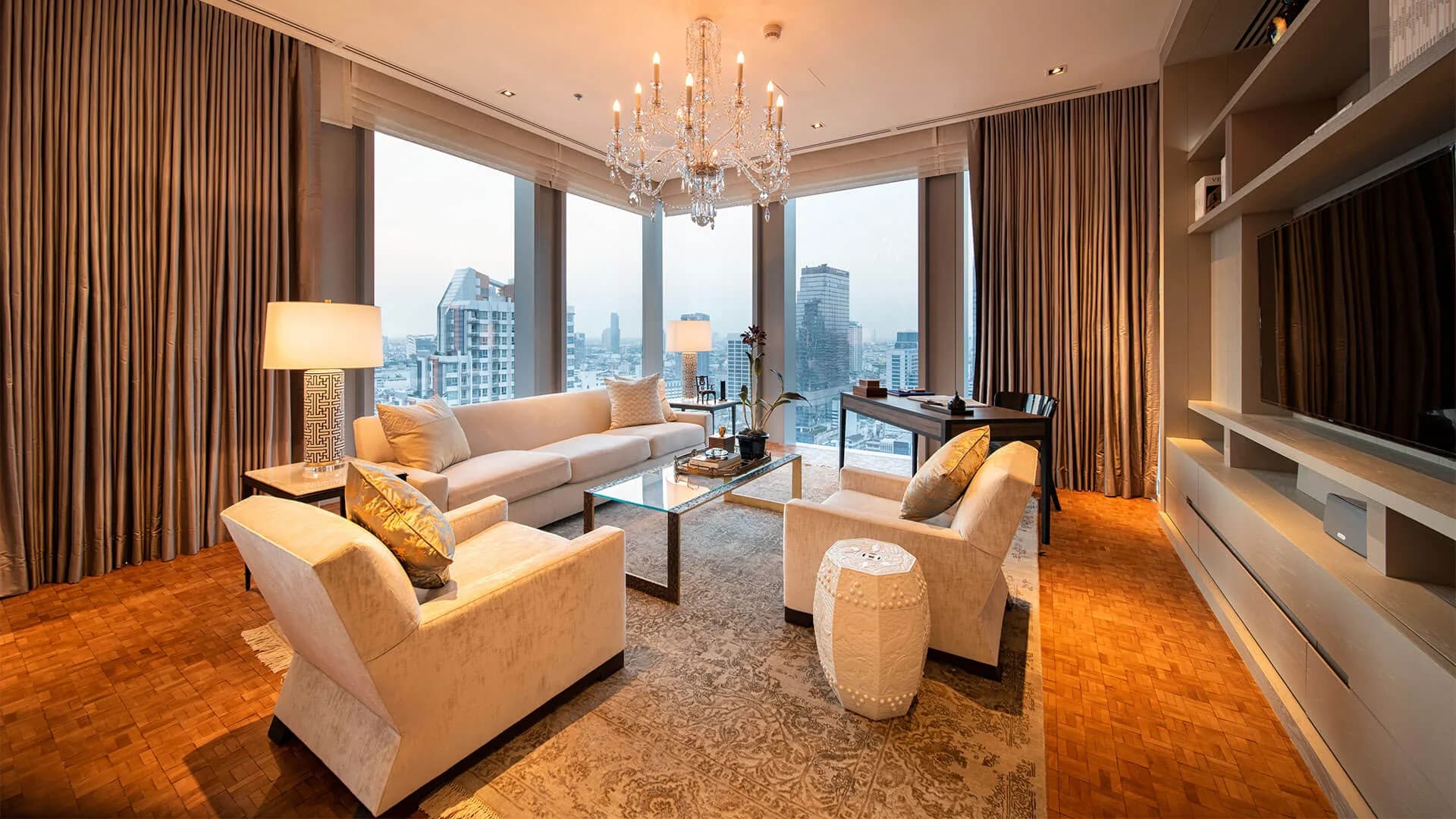 Corner living room in a Ritz-Carlton Residences Bangkok apartment with floor-to-ceiling windows over the city