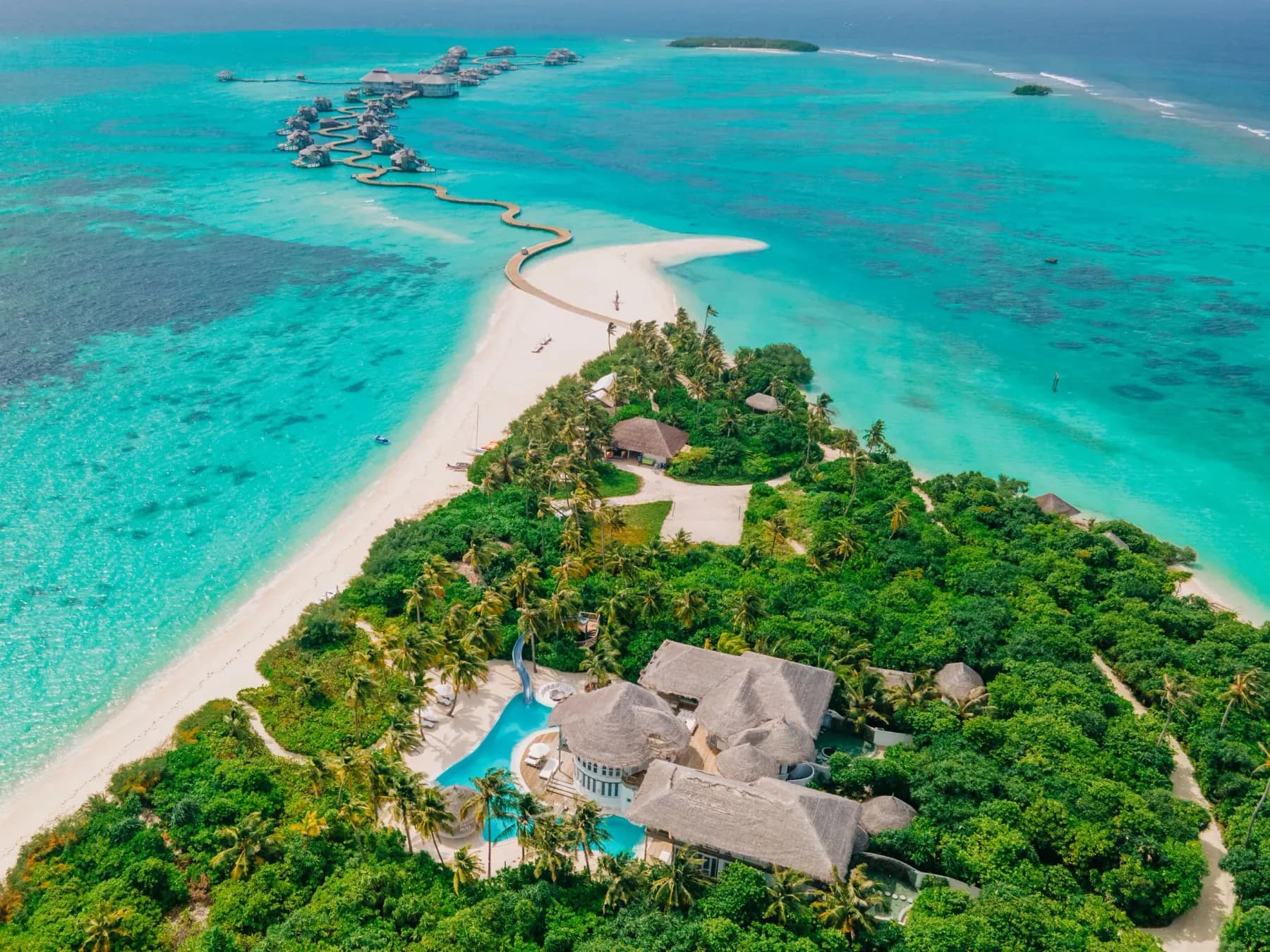 A Soneva Jani private residence on Medhufaru from above, with the resort's water villas across the lagoon.