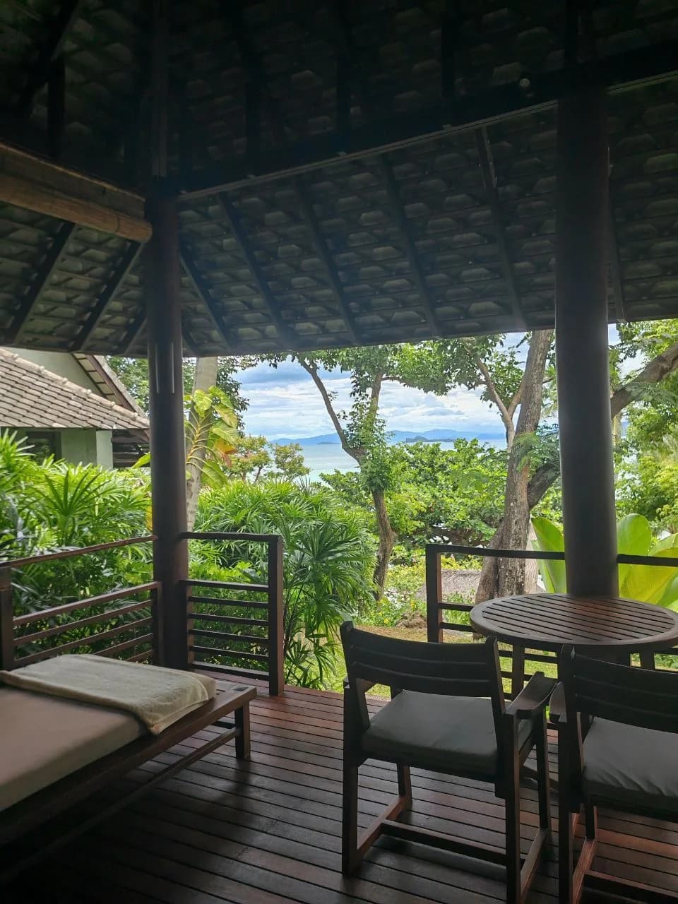 Balcony daybed and table of a Villa Sea View at Kamalaya Koh Samui, looking through the trees to the Gulf of Thailand