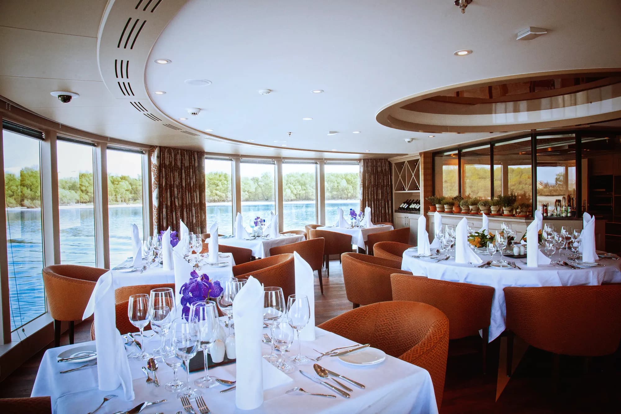 The Chef's Table restaurant on AmaReina, tables laid by curved windows over the river