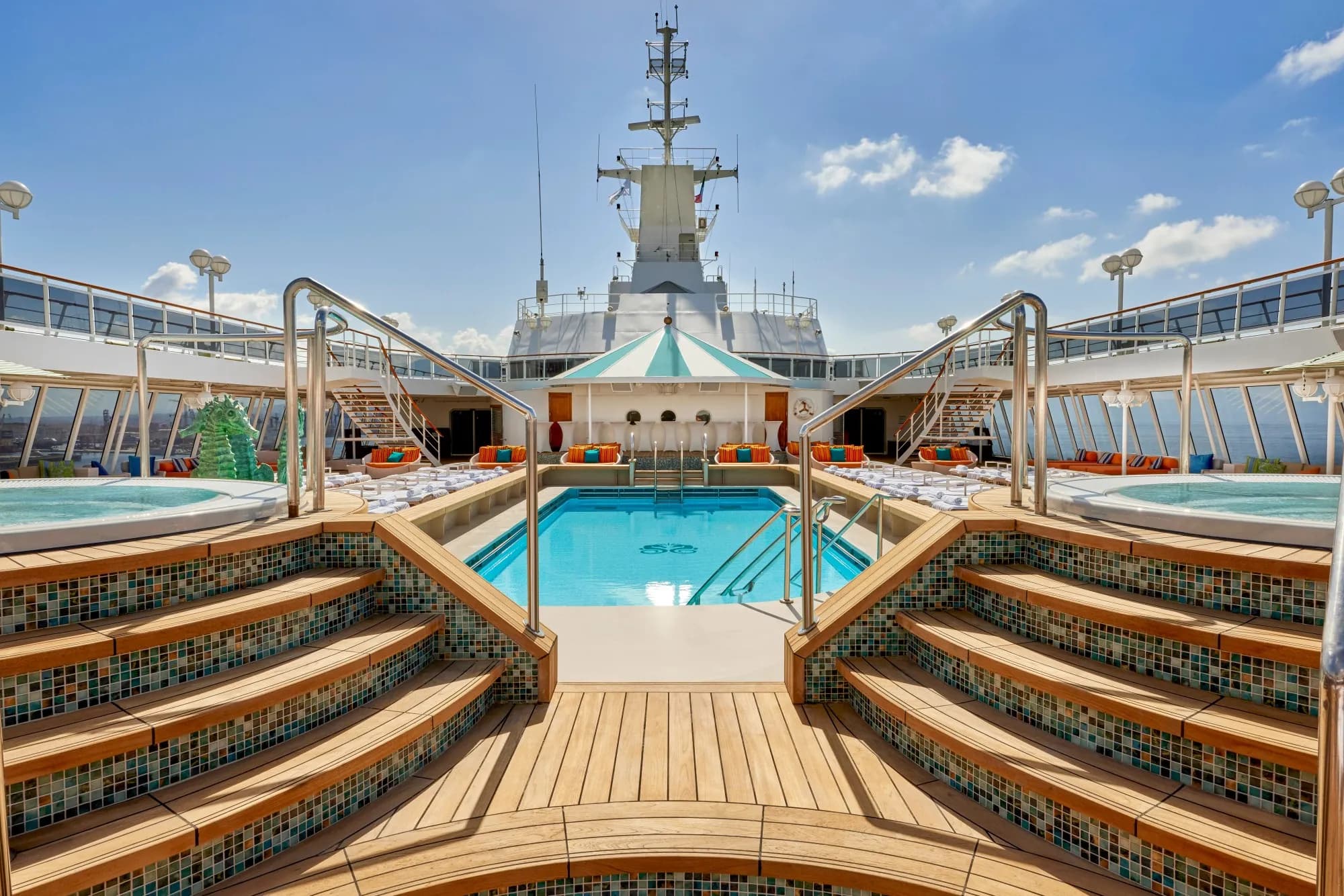 The Seahorse Pool on Crystal Serenity, teak steps and mosaic risers down to the pool with a whirlpool either side