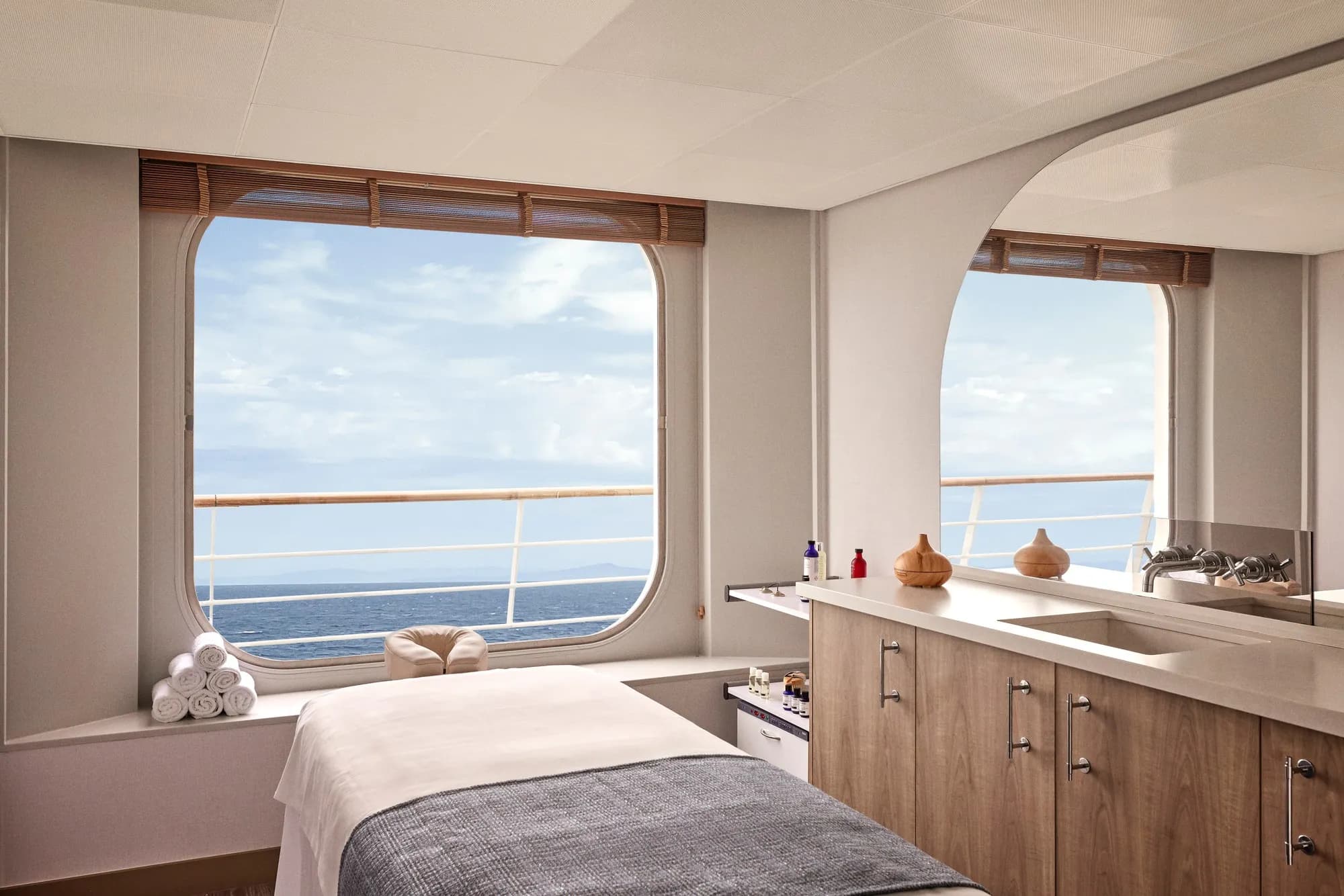 A spa treatment room on a Crystal ship, massage table beside a large window over the open sea