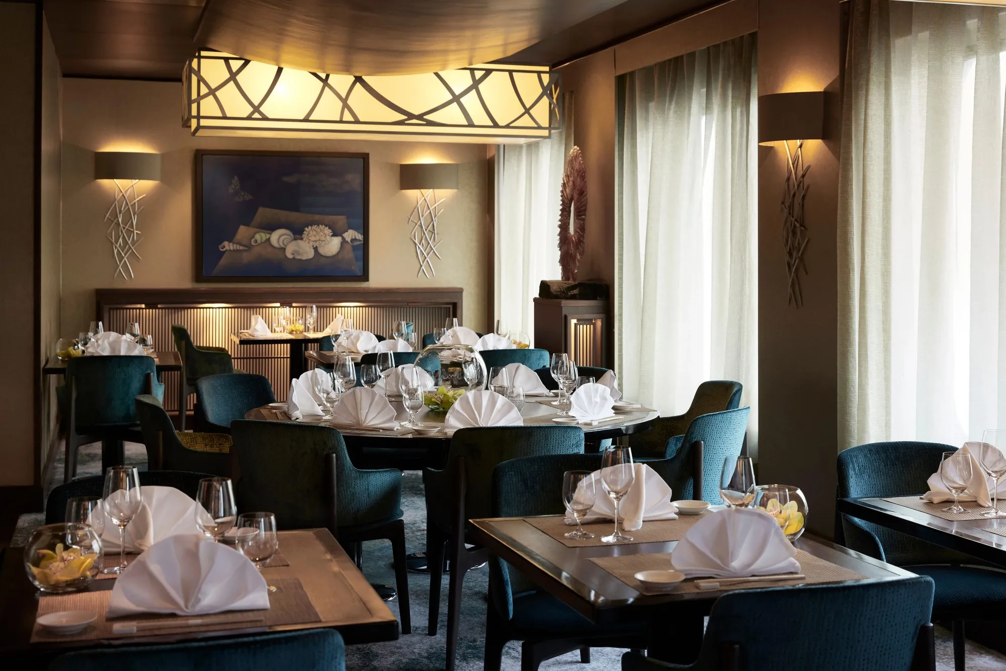 Umi Uma, the Nobu restaurant on Crystal Symphony, tables laid for dinner under a lantern-style light