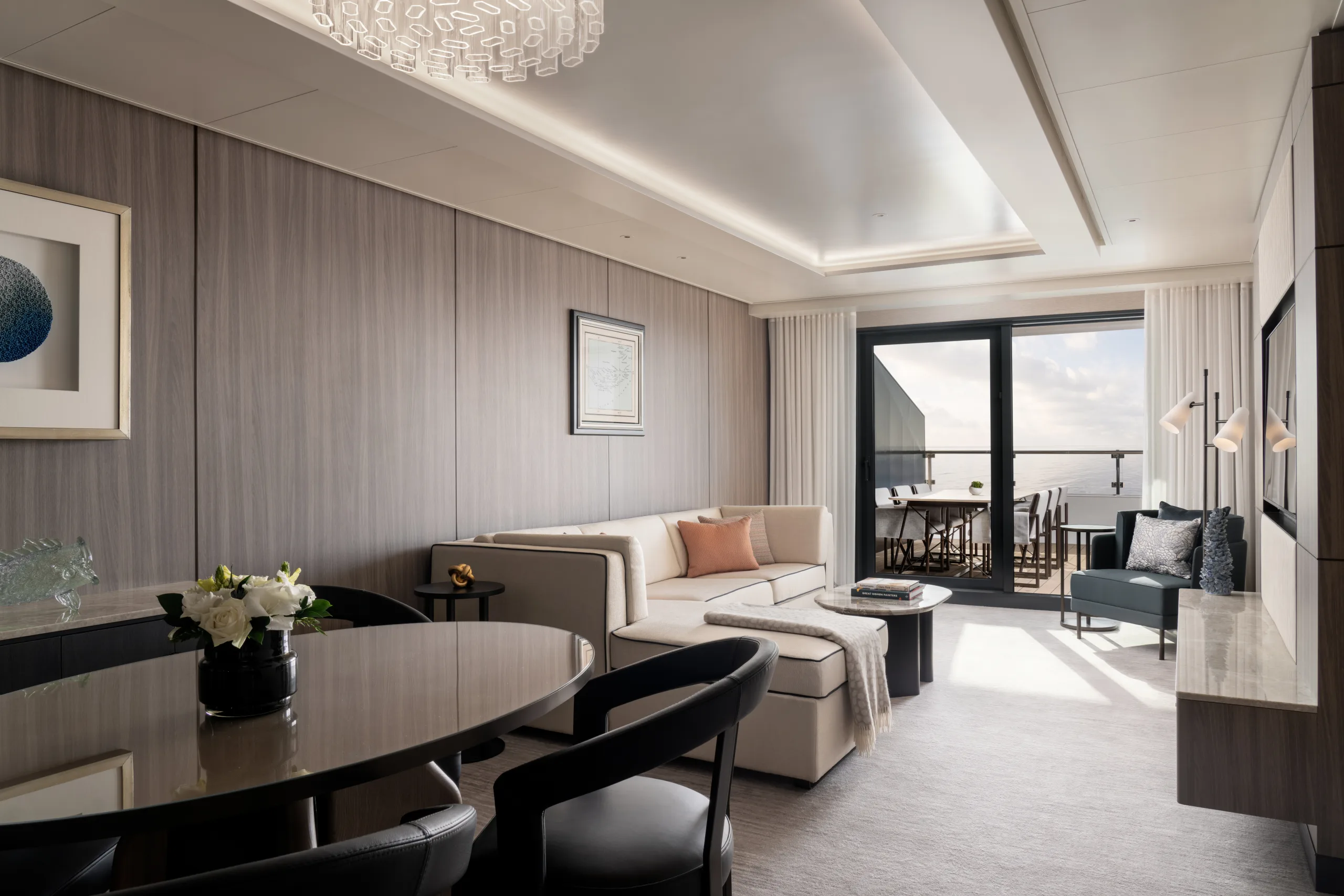 A Concierge Suite aboard Ilma, dining table and living area under floor-to-ceiling glass