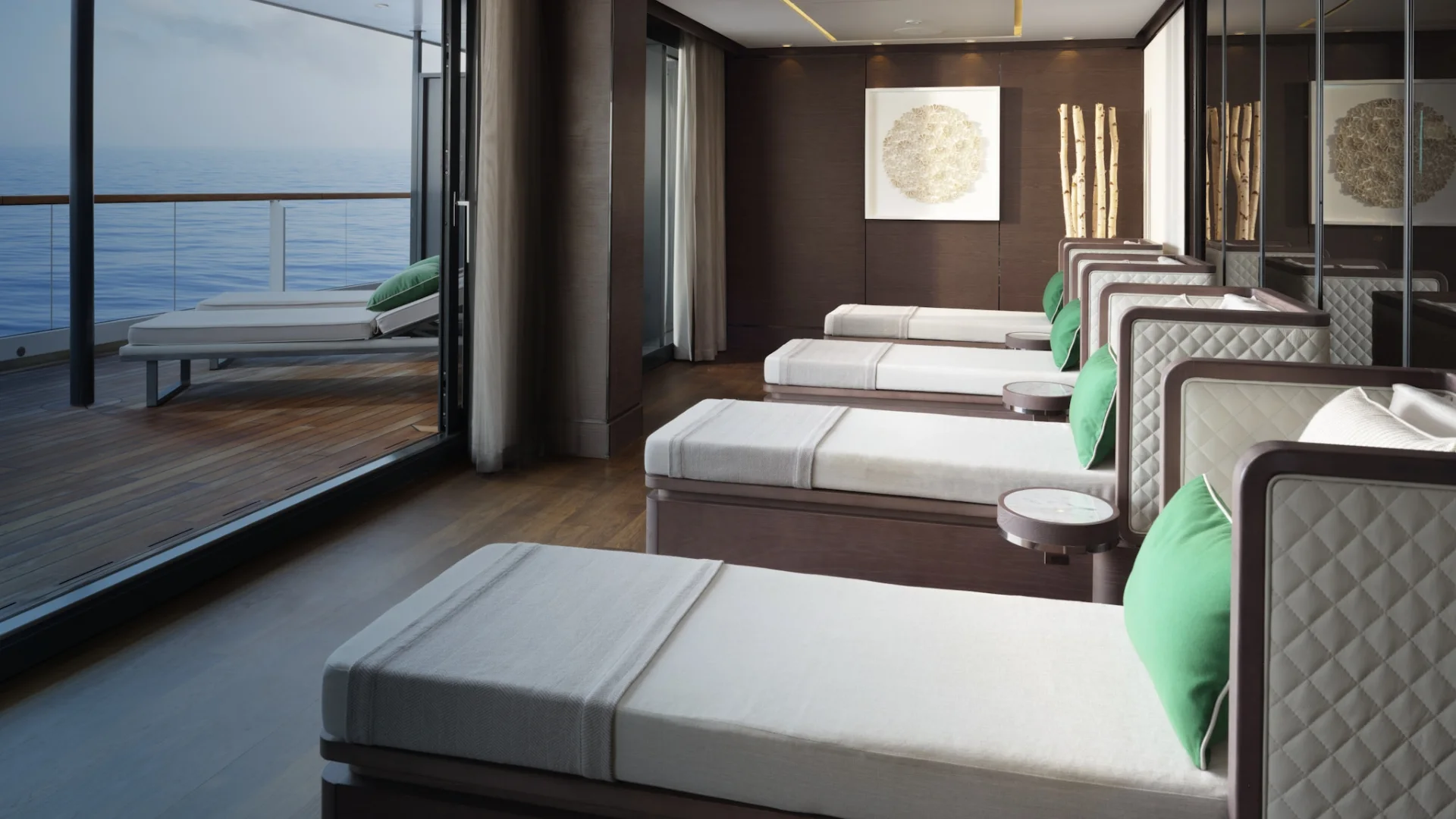 Relaxation room of the spa on a Ritz-Carlton yacht, daybeds facing open glass doors onto a deck and the sea