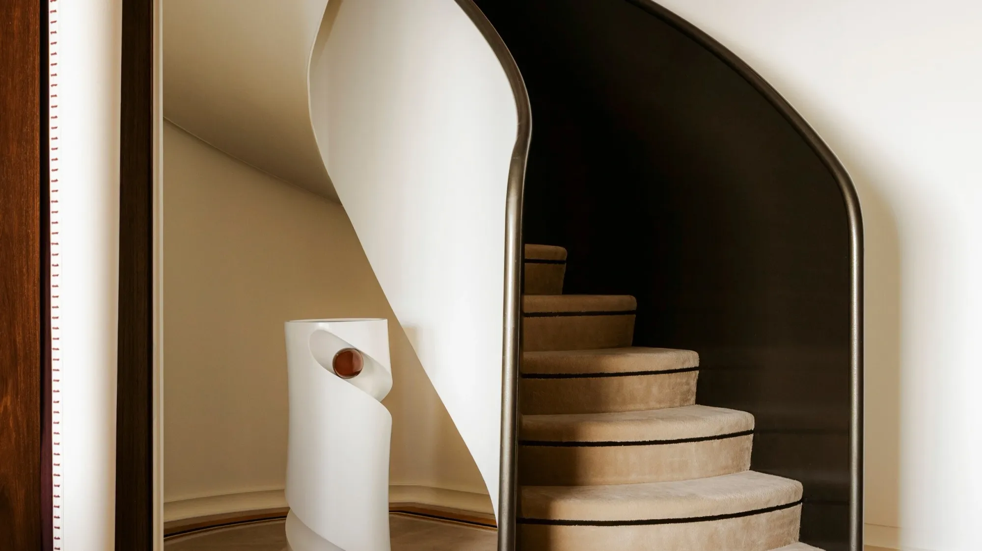 The curved staircase between the two levels of a Suite Duplex on Orient Express Corinthian
