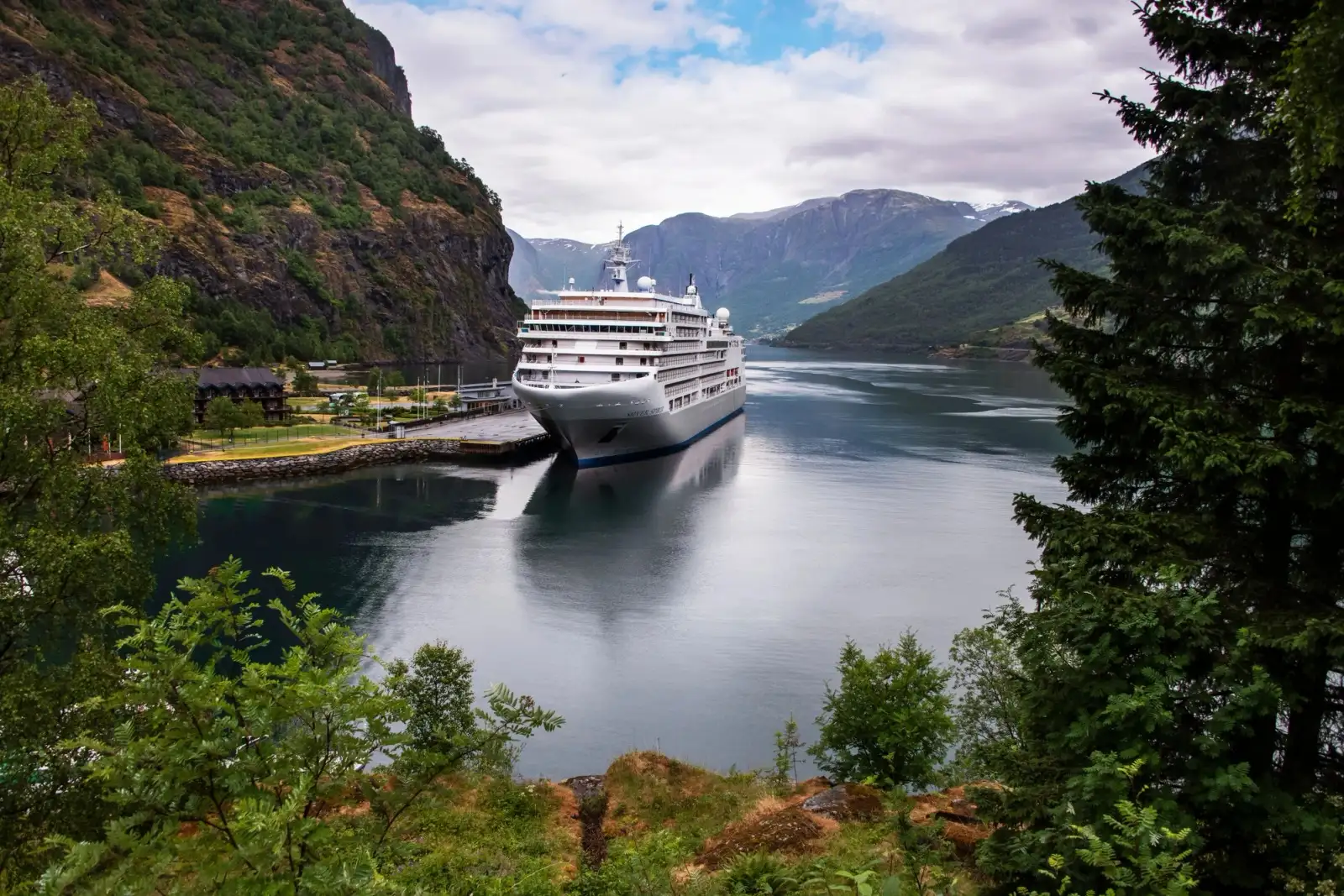 Silver Spirit moored at the head of a fjord below steep green mountains