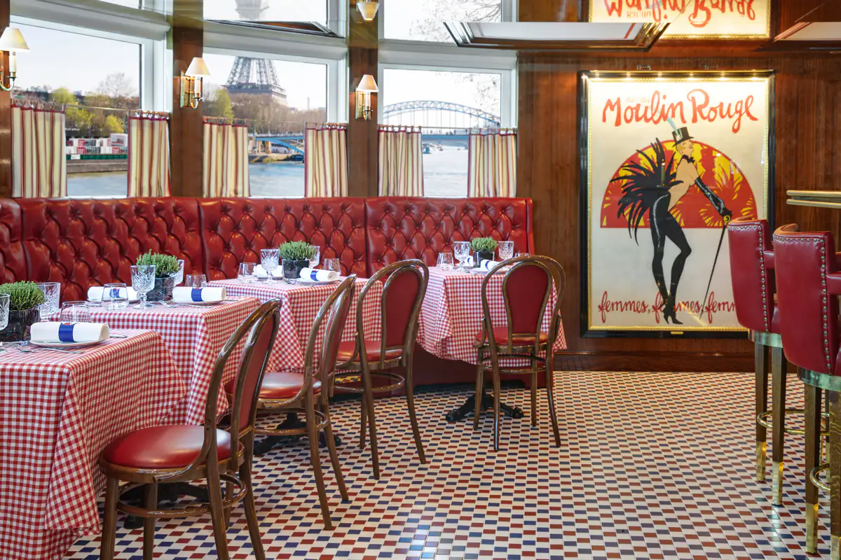 Le Bistrot on S.S. Joie de Vivre, red banquettes and checked tablecloths, the Eiffel Tower through the window
