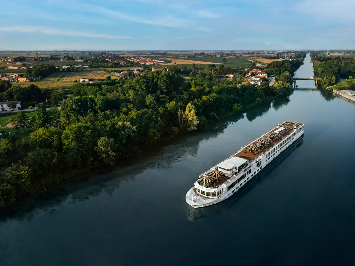 S.S. La Venezia on a tree-lined waterway through farmland, seen from above