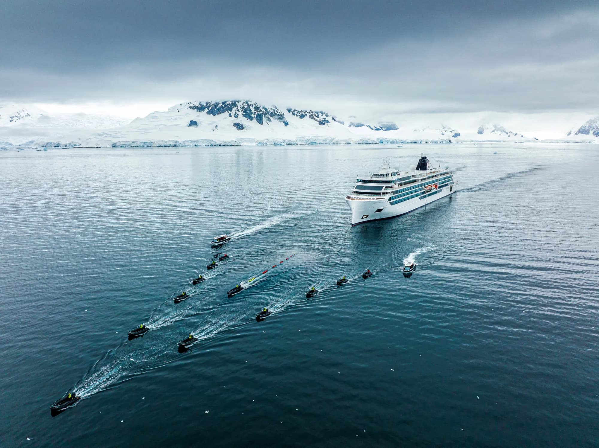 A Viking expedition ship in Antarctic waters with a fleet of Zodiacs and two Special Operations Boats fanning out ahead