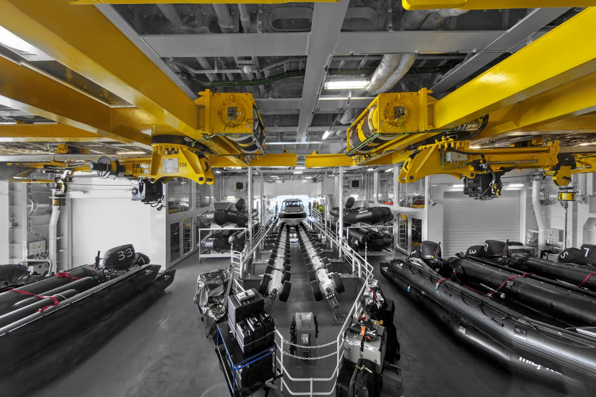 The Hangar on Viking Octantis, rows of Zodiacs either side of a central slipway under yellow cranes
