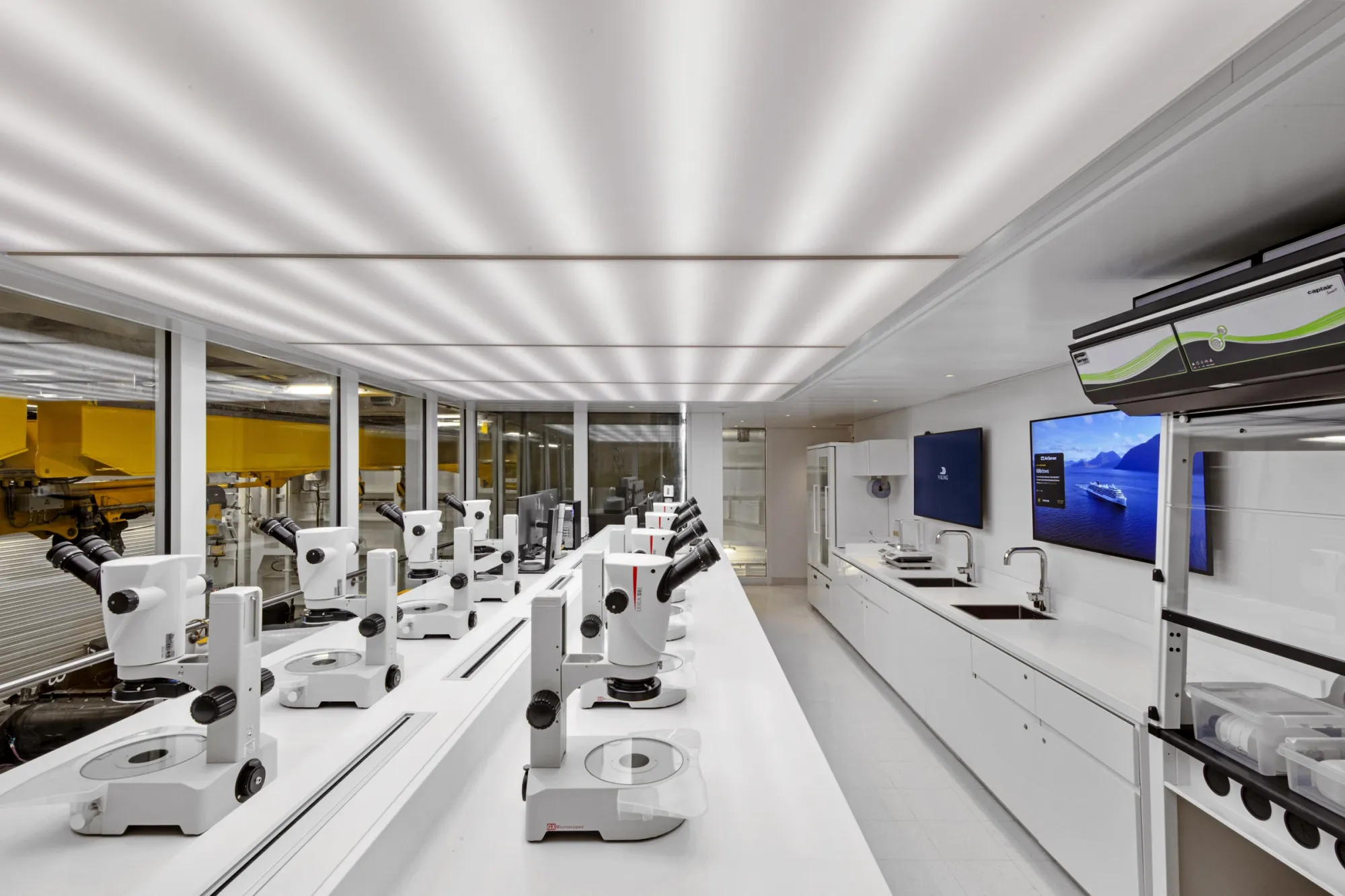 The Science Lab on Viking Octantis, white benches lined with microscopes, the Hangar's cranes through the glass