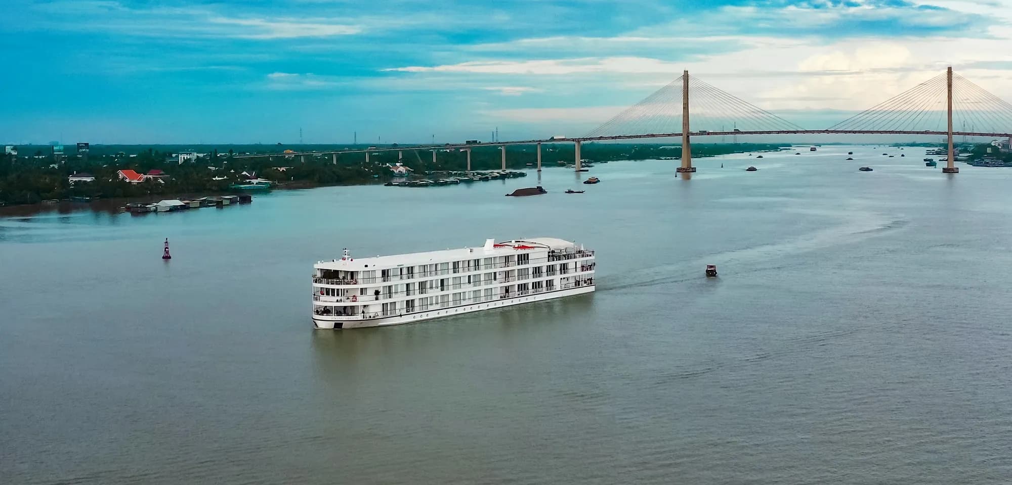 A Viking river ship on the wide Mekong in Vietnam, a cable-stayed bridge on the horizon