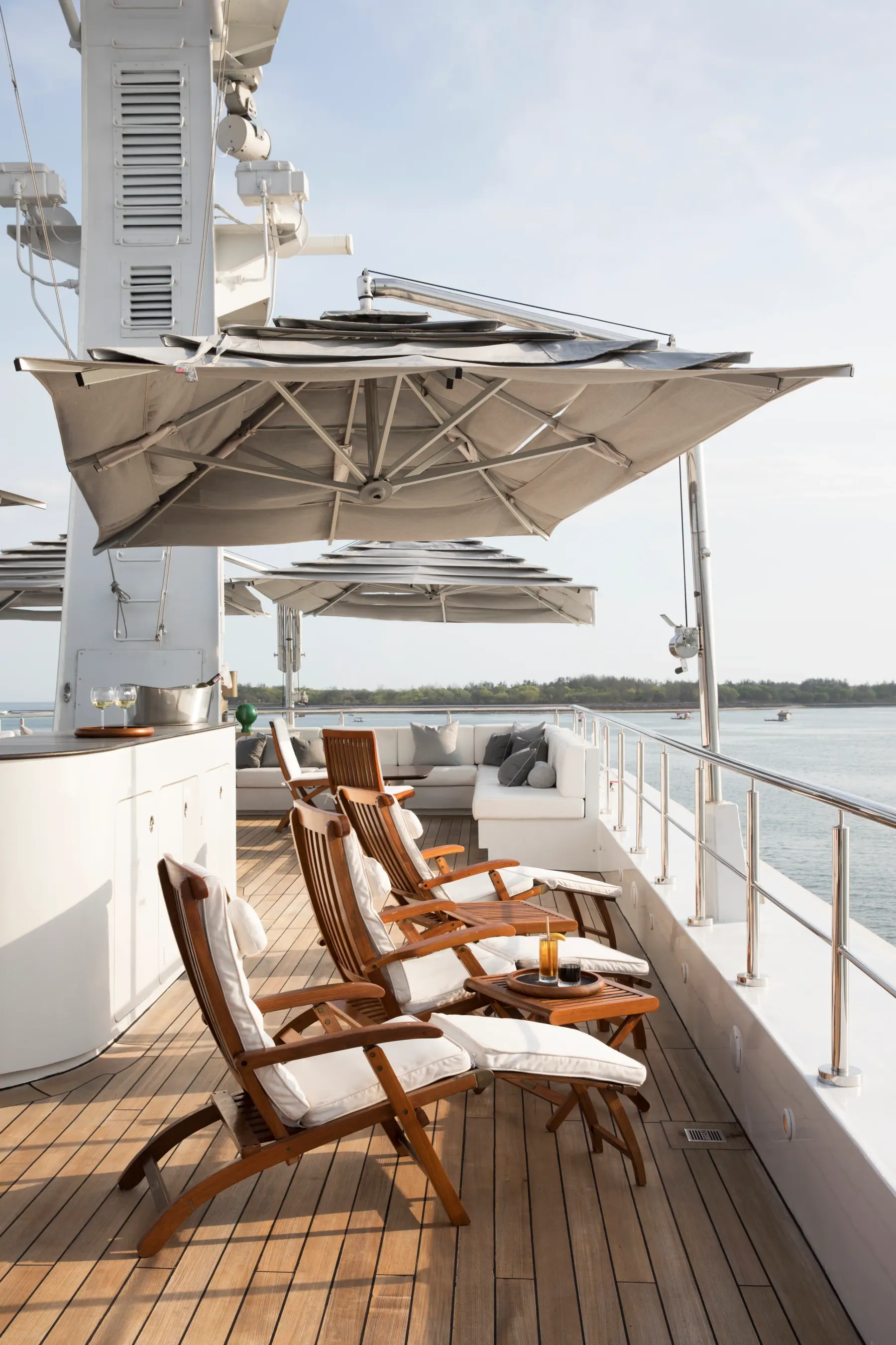 Teak steamer chairs under parasols on Aqua Blu's sun deck