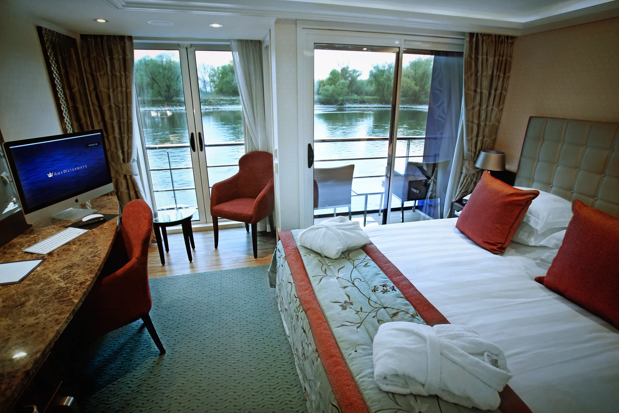 A twin-balcony stateroom on AmaReina, a French balcony and a step-out balcony both open onto the river